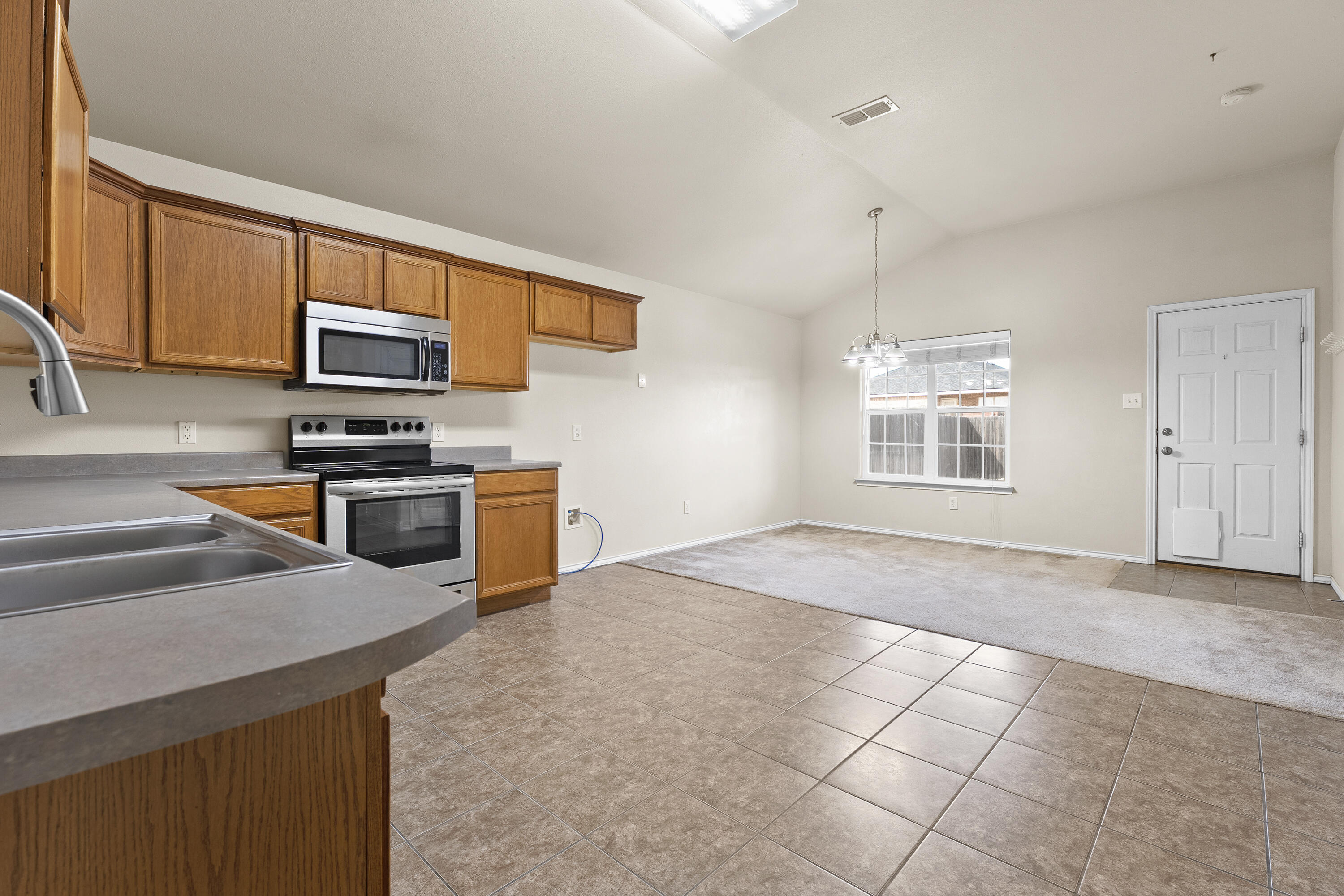 6522 93rd Street Lubbock, TX 79424 - Photo 7 of 22 a kitchen with stainless steel appliances a stove sink and microwave