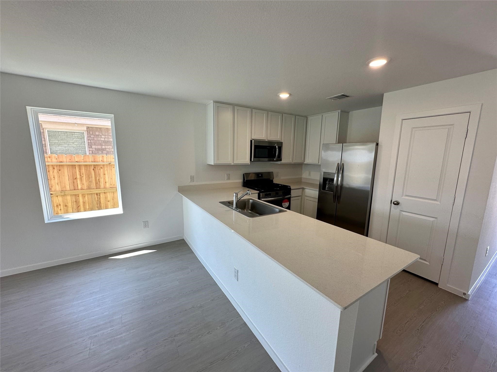 2115 Mosaic Vly Court Angleton, TX 77515 - Photo 7 of 16 a kitchen with stainless steel appliances a refrigerator stove microwave and sink