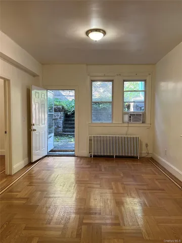 a view of an empty room with glass door and windows
