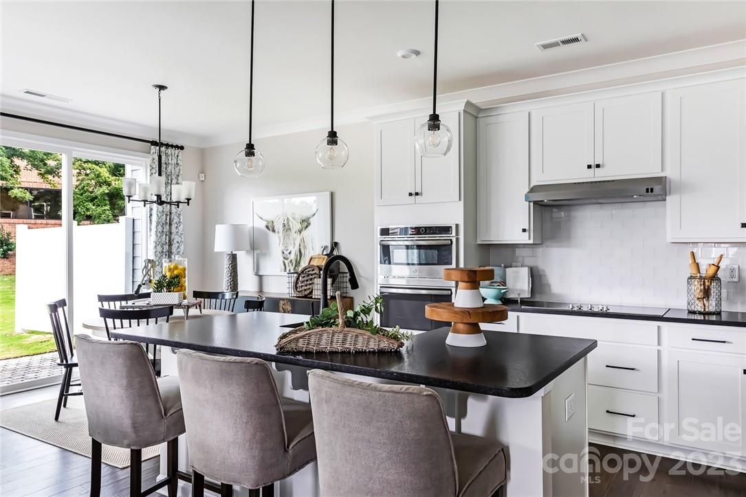 216 Brooks Springs Drive Fort Mill, SC 29708 - Photo 9 of 24 a kitchen with stainless steel appliances granite countertop a sink a stove and chairs