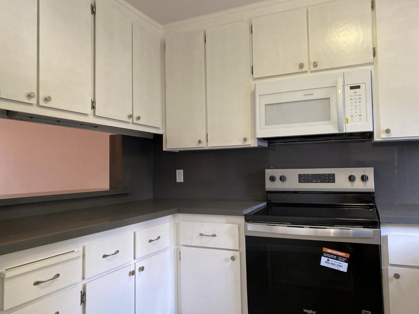 18003 Incline Place Hayward, CA 94541 - Photo 4 of 7 a kitchen with white cabinets and black appliances