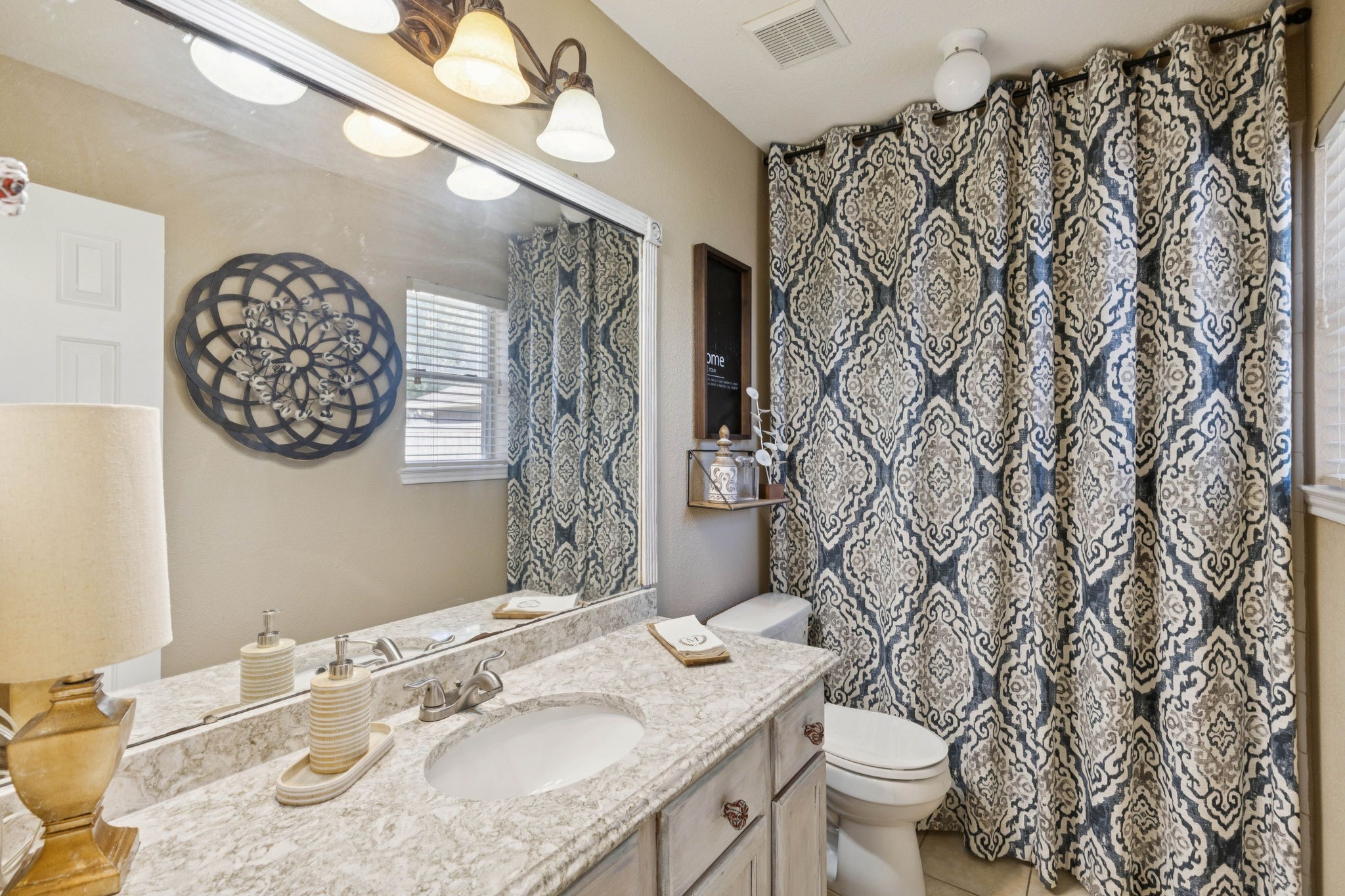 16322 Mango Ridge Court Humble, TX 77396 - Photo 13 of 20 a bathroom with a granite countertop sink and a mirror