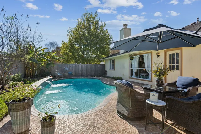 a view of a chair and table in backyard of the house