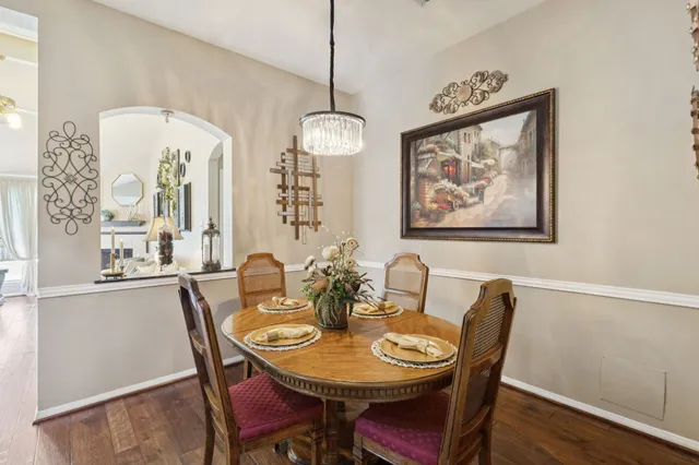 a dining room with furniture a chandelier and wooden floor