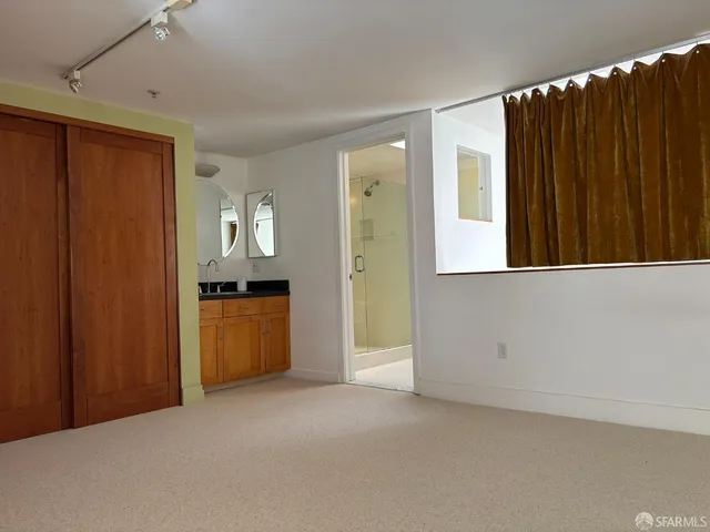 a view of an empty room with a fireplace and a window