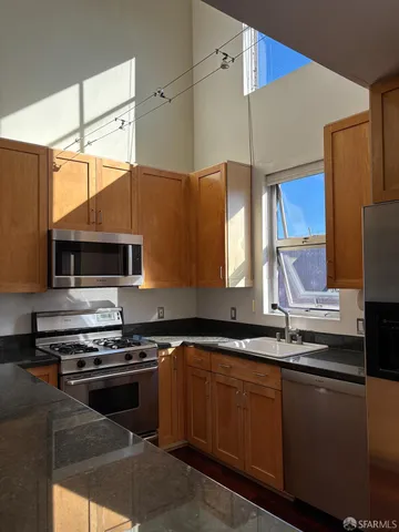 a kitchen with stainless steel appliances a sink dishwasher a stove and a microwave oven