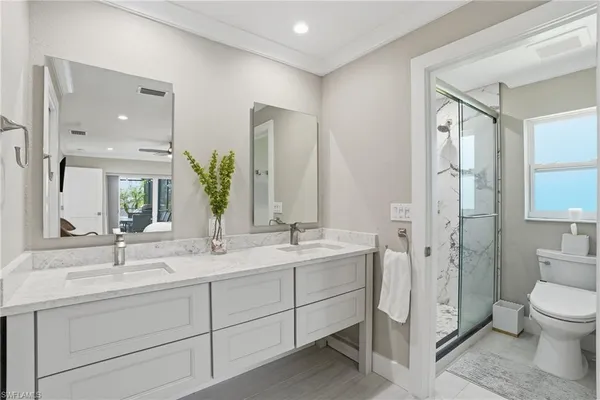 a bathroom with a double vanity sink mirror and toilet