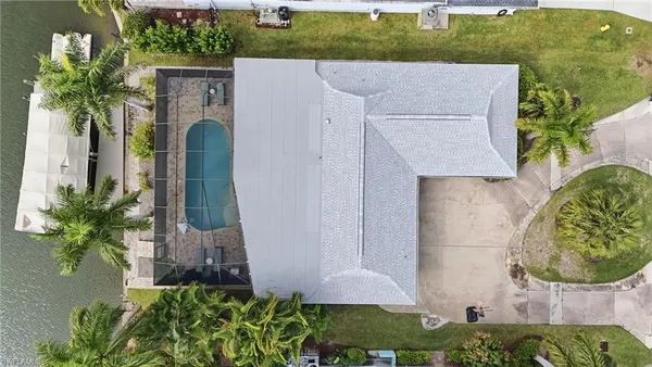 a aerial view of a house with swimming pool and large trees