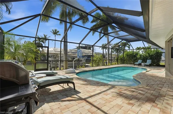 a view of a patio with a table and chairs under an umbrella