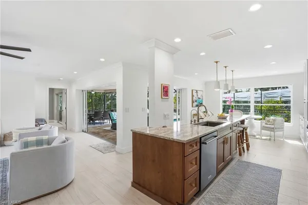 a large kitchen with stainless steel appliances kitchen island a large counter top and a view of living room