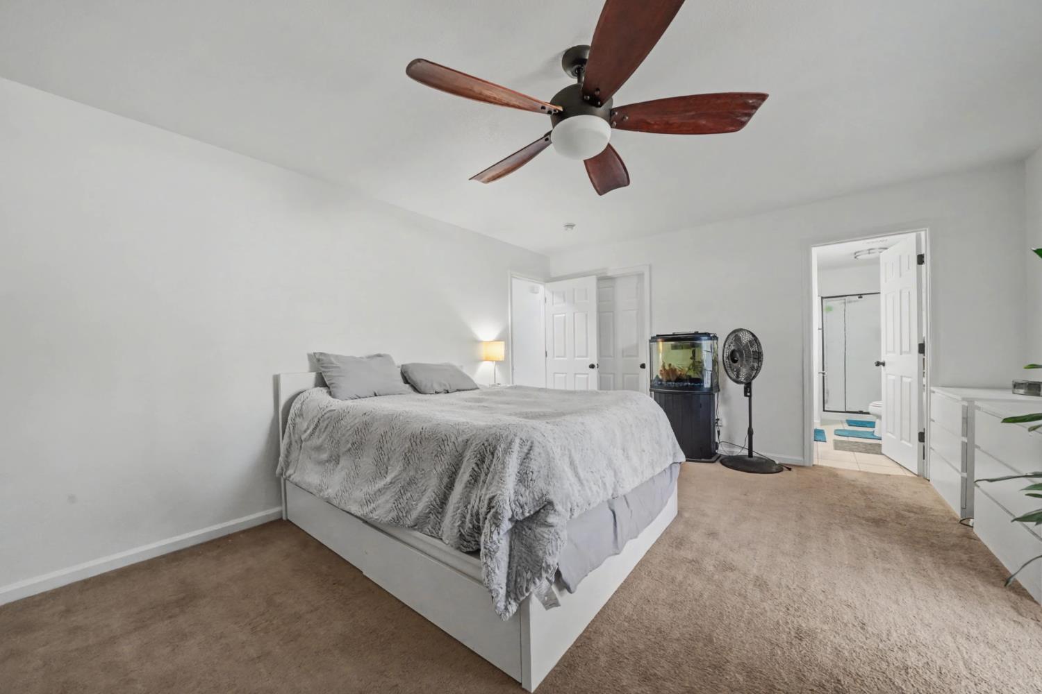 7761 Jenny Lind Road Valley Springs, CA 95252 - Photo 19 of 35 a spacious bedroom with a bed and a ceiling fan