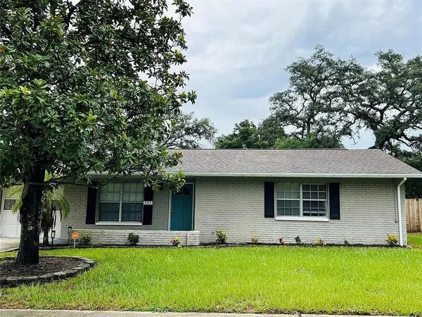 a front view of a house with a yard and tree