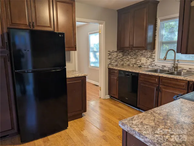 a kitchen with stainless steel appliances granite countertop a refrigerator and a sink