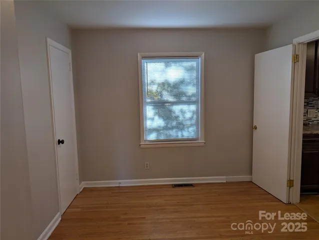a view of an empty room with window and closet area