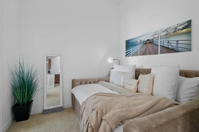 a bedroom with a bed and a potted plant