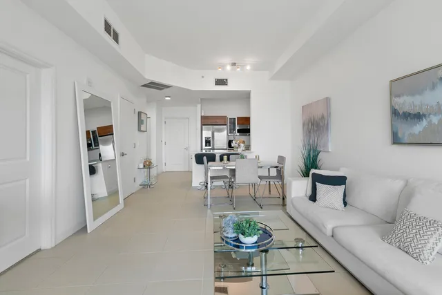 a living room with furniture and a dining table with wooden floor