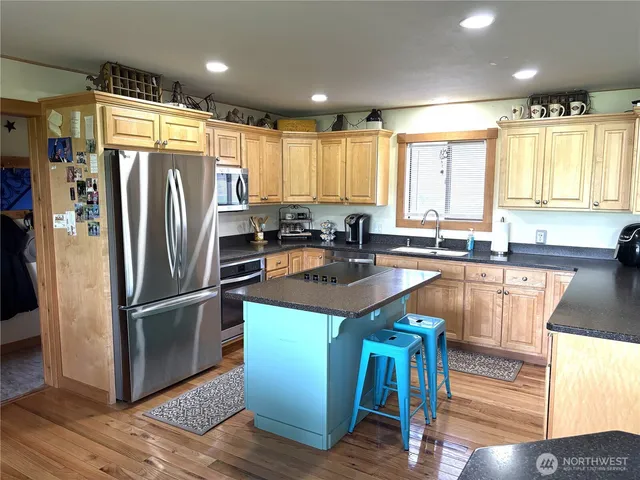 a kitchen with stainless steel appliances granite countertop a refrigerator a sink and a stove