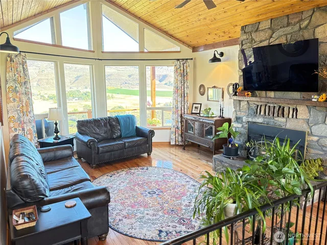 a living room with furniture a flat screen tv and a floor to ceiling window