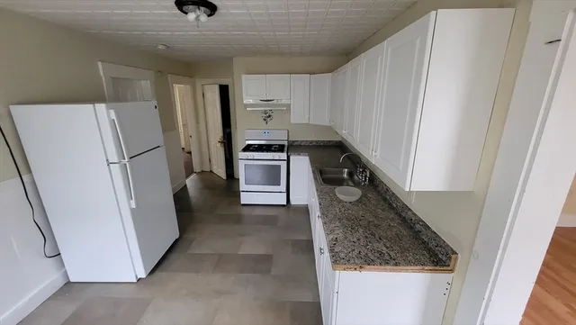 a kitchen with a refrigerator a stove and cabinets