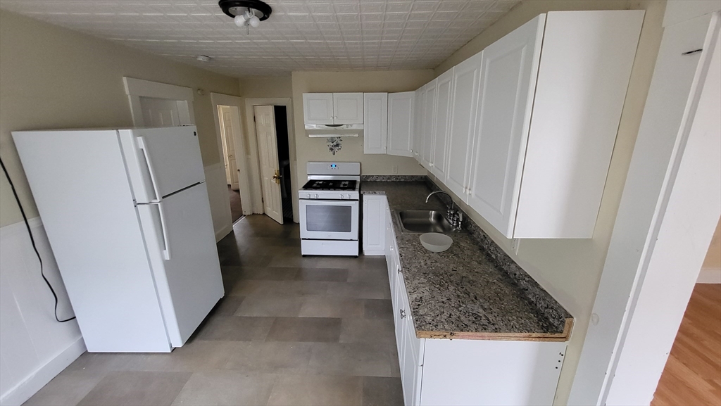 238 Hildreth Street, Unit 238 Lowell, MA 01850 - Photo 2 of 16 a kitchen with a refrigerator a stove and cabinets
