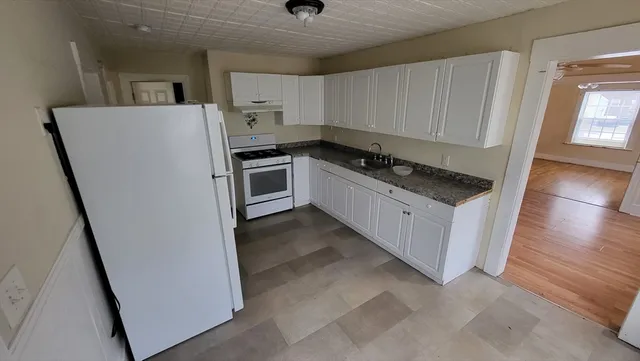 a kitchen with white cabinets and white appliances