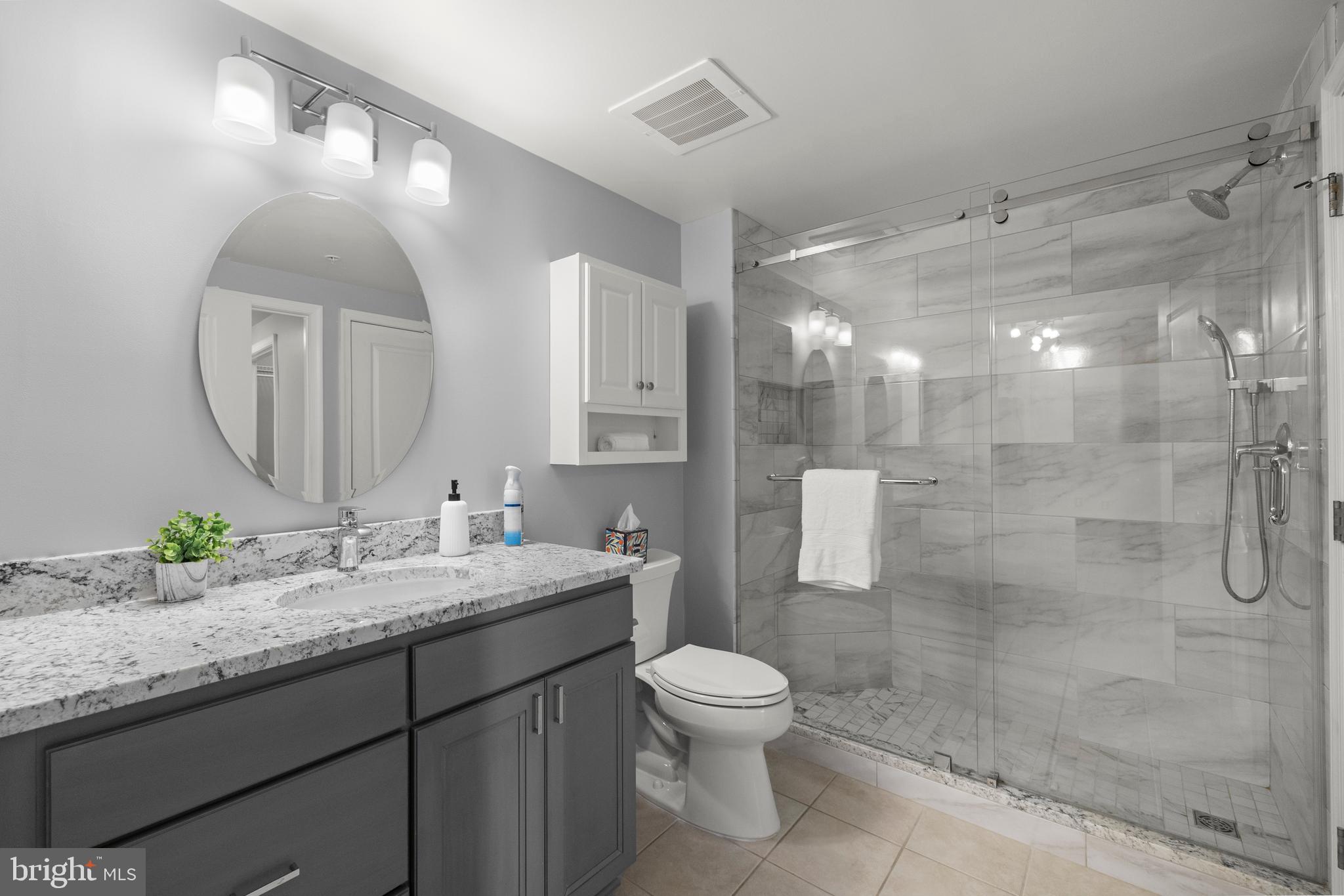 851 North Glebe Road, Unit 1508 Arlington, VA 22203 - Photo 23 of 41 a bathroom with a granite countertop sink mirror toilet and shower