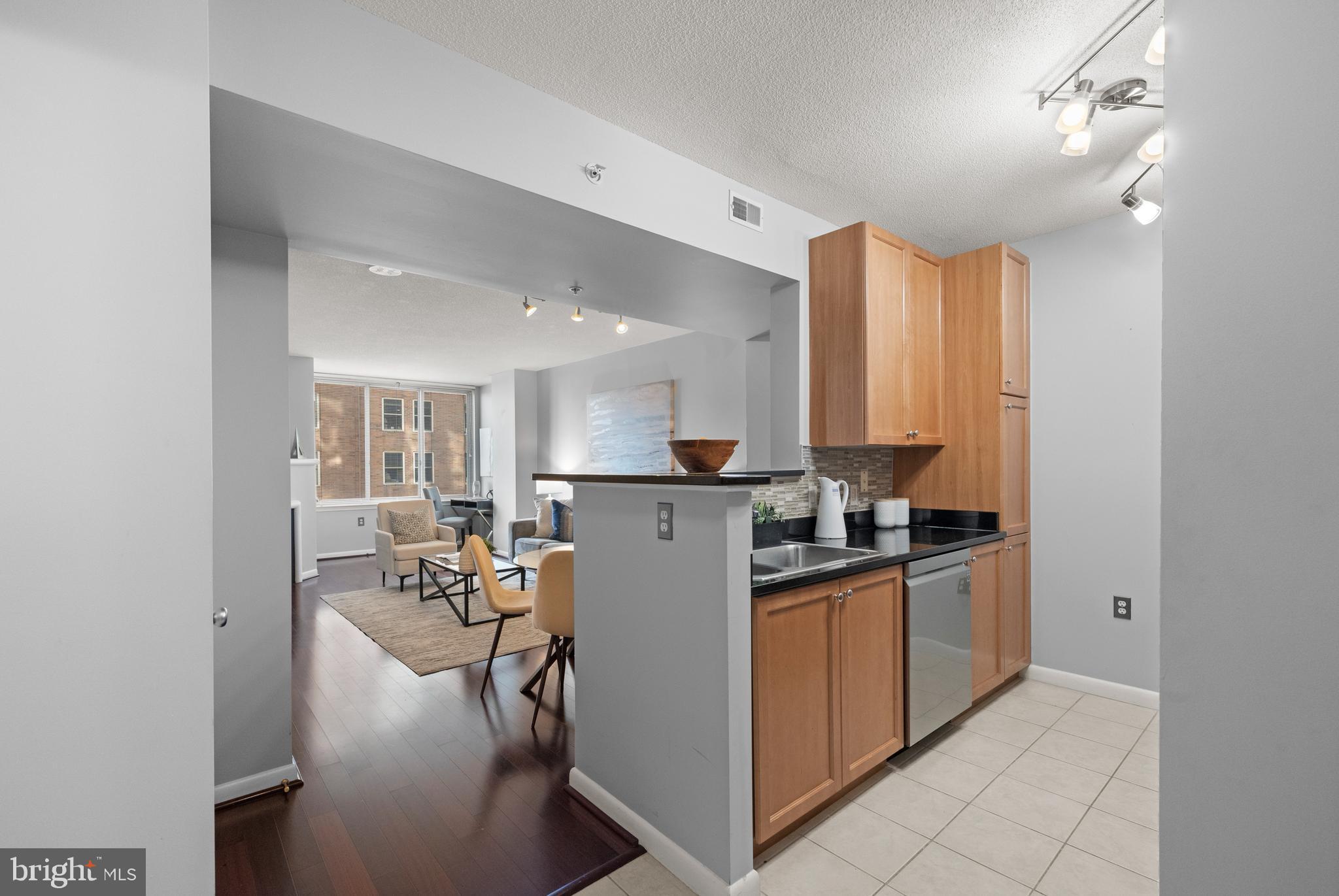 851 North Glebe Road, Unit 1508 Arlington, VA 22203 - Photo 4 of 41 a kitchen with stainless steel appliances granite countertop a stove top oven a sink a refrigerator and white cabinets