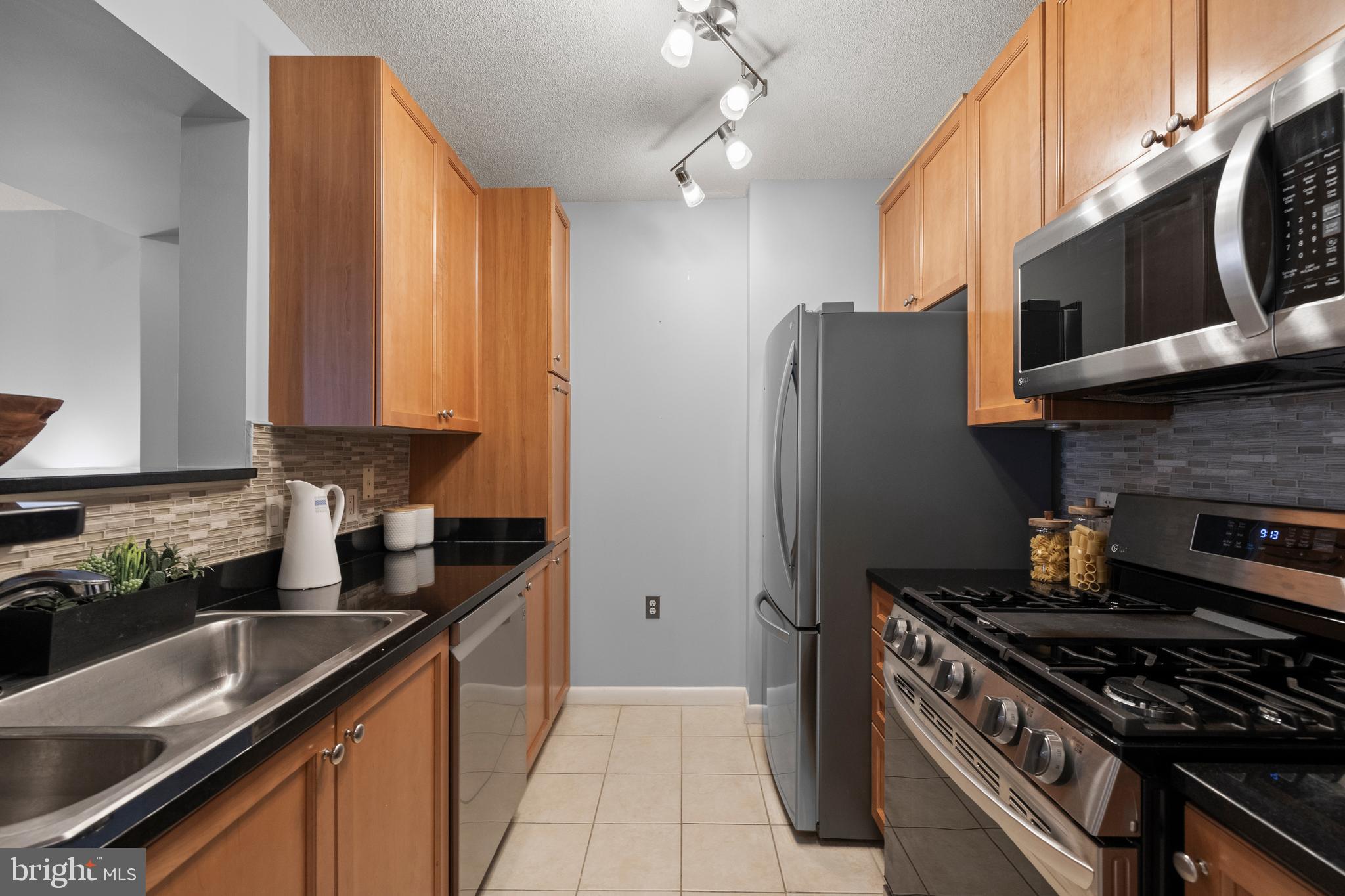 851 North Glebe Road, Unit 1508 Arlington, VA 22203 - Photo 6 of 41 a kitchen with stainless steel appliances granite countertop a refrigerator a sink dishwasher a stove and a microwave oven with cabinets