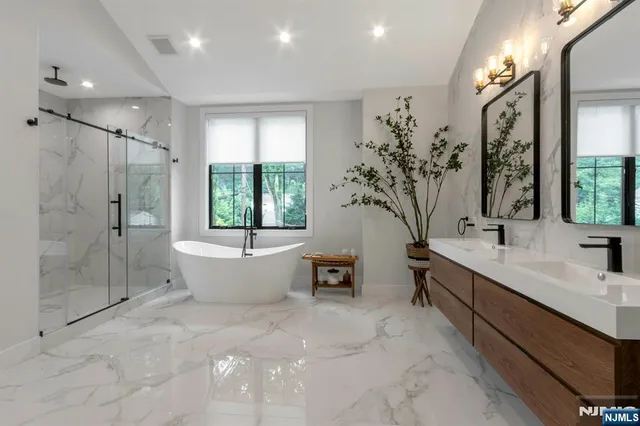 a bathroom with a large tub a sink a window and a shower