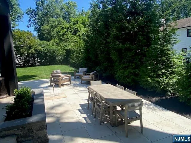 a view of a patio with table and chairs potted plants with wooden floor and fence
