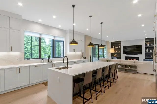 a large kitchen with kitchen island a sink table and chairs
