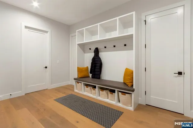 a view of a bedroom with wooden floor and white walls