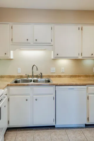 a kitchen with granite countertop white cabinets and white appliances