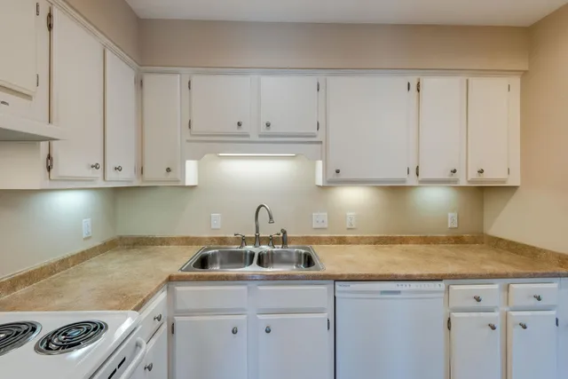 a kitchen with cabinets and white stainless steel appliances