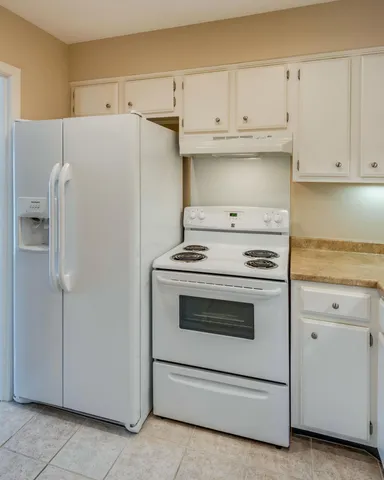 a kitchen with white cabinets and white appliances