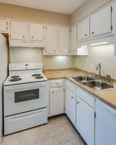 a kitchen with white cabinets and white appliances