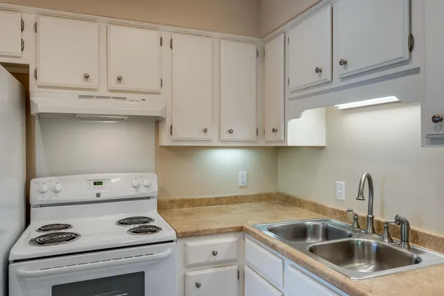 a kitchen with cabinets appliances and a sink