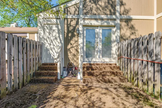 a view of a house with a small yard and wooden floor and fence
