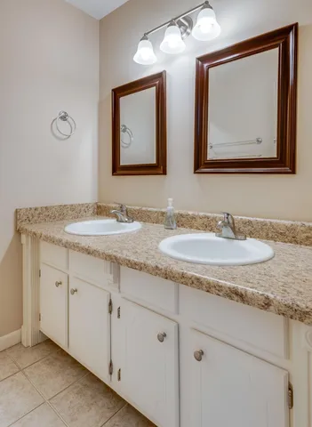 a bathroom with double sink and a mirror