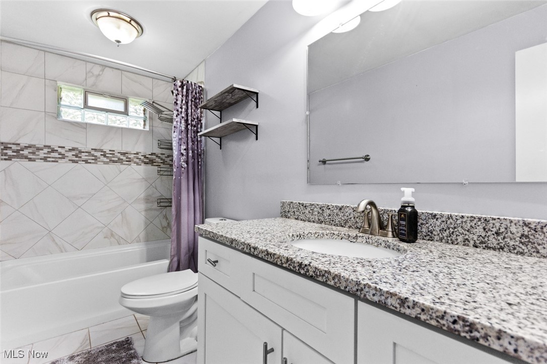 1824 Amherst Road Northeast Massillon, OH 44646 - Photo 17 of 34 Full bathroom featuring toilet, vanity, and shower / bathtub combination with curtain