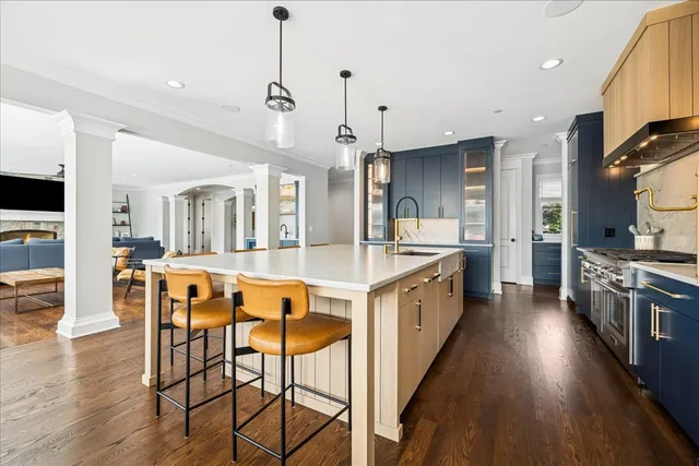 a large kitchen with kitchen island wooden floors and stainless steel appliances