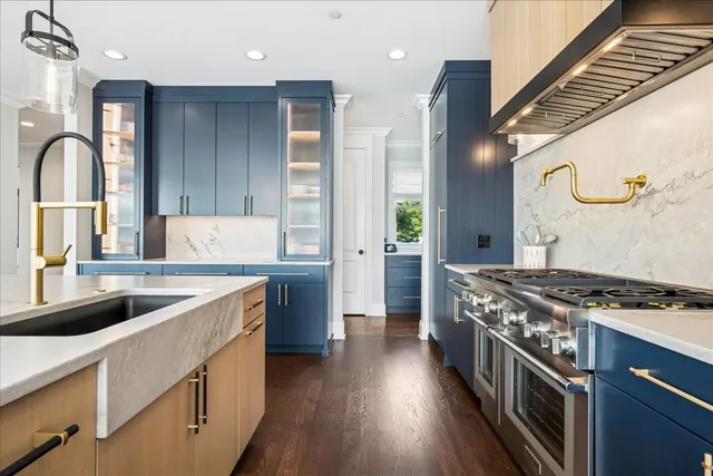 a kitchen with stainless steel appliances granite countertop a stove a sink and a refrigerator