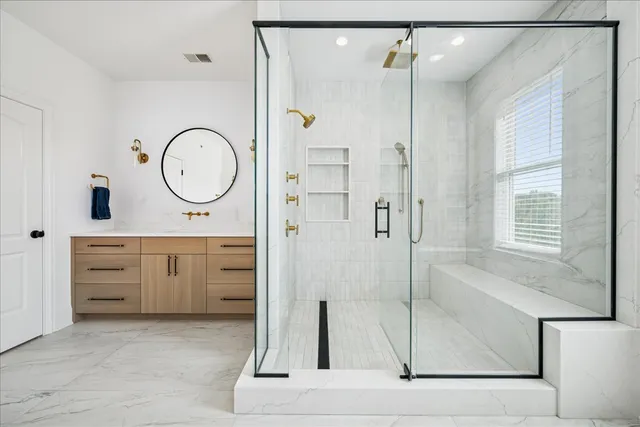 a bathroom with a double vanity sink a mirror a shower and a bathtub