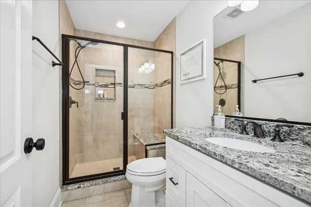 a bathroom with a granite countertop sink toilet and shower