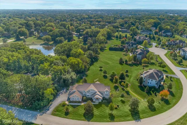 an aerial view of residential house with outdoor space and trees all around