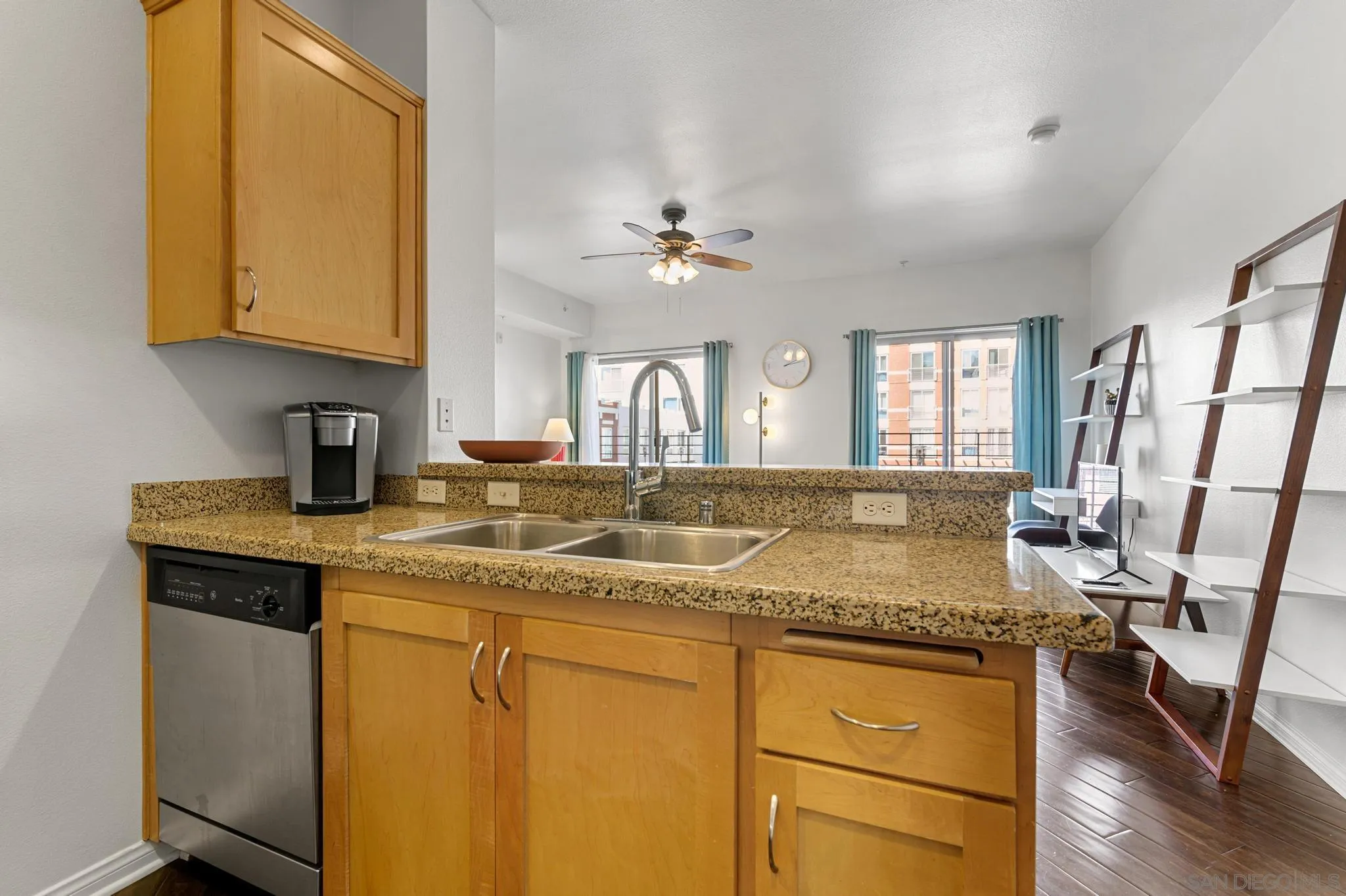 450 J Street, Unit 4121 San Diego, CA 92101 - Photo 7 of 22 a kitchen with granite countertop a sink stainless steel appliances white cabinets and wooden floor