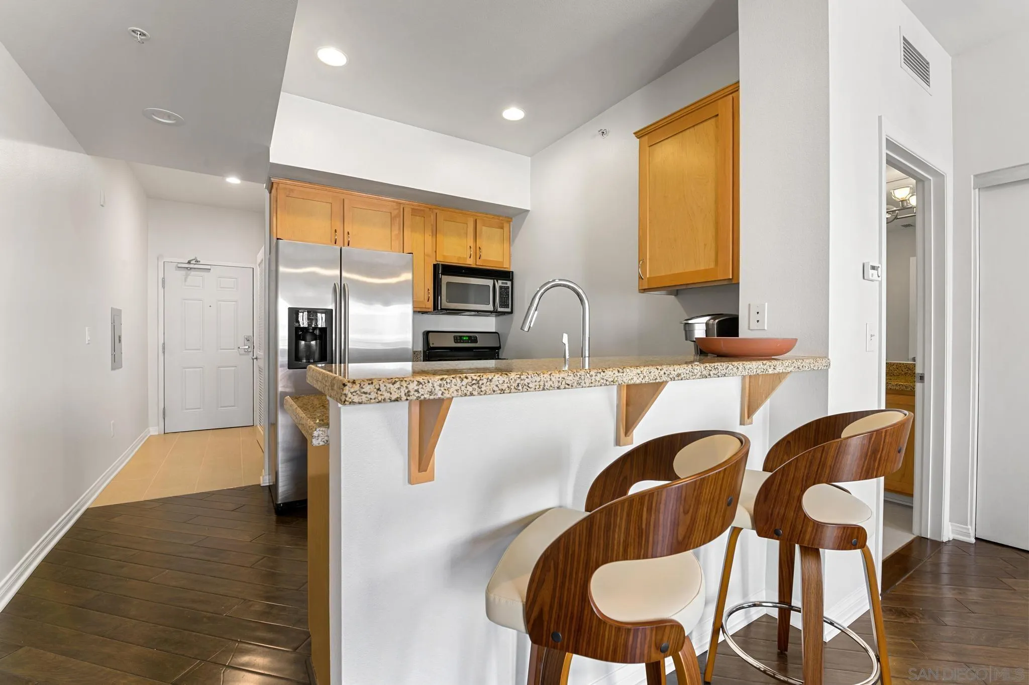 450 J Street, Unit 4121 San Diego, CA 92101 - Photo 8 of 22 a kitchen with granite countertop a table chairs microwave and sink