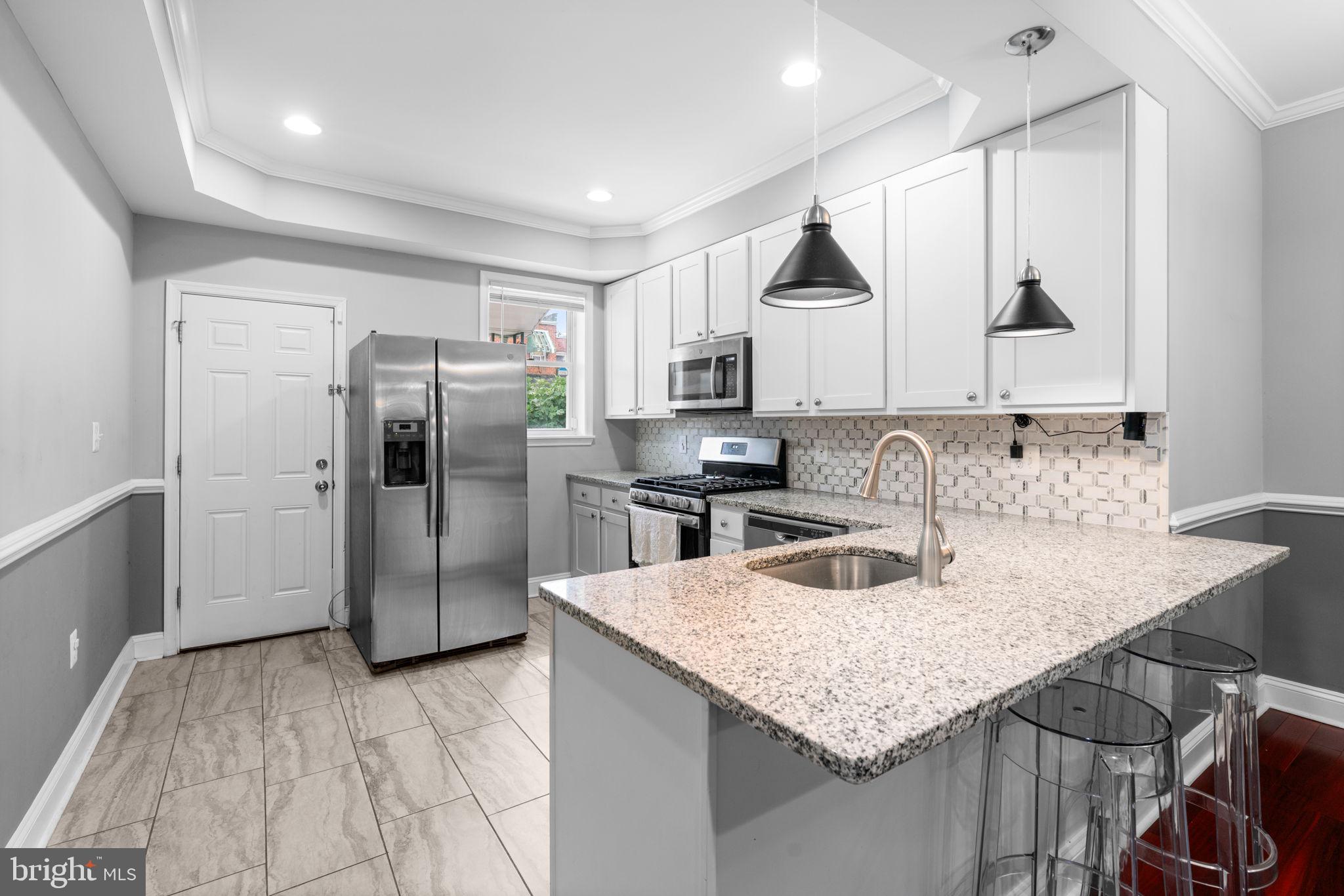 a kitchen with stainless steel appliances granite countertop a sink refrigerator and cabinets
