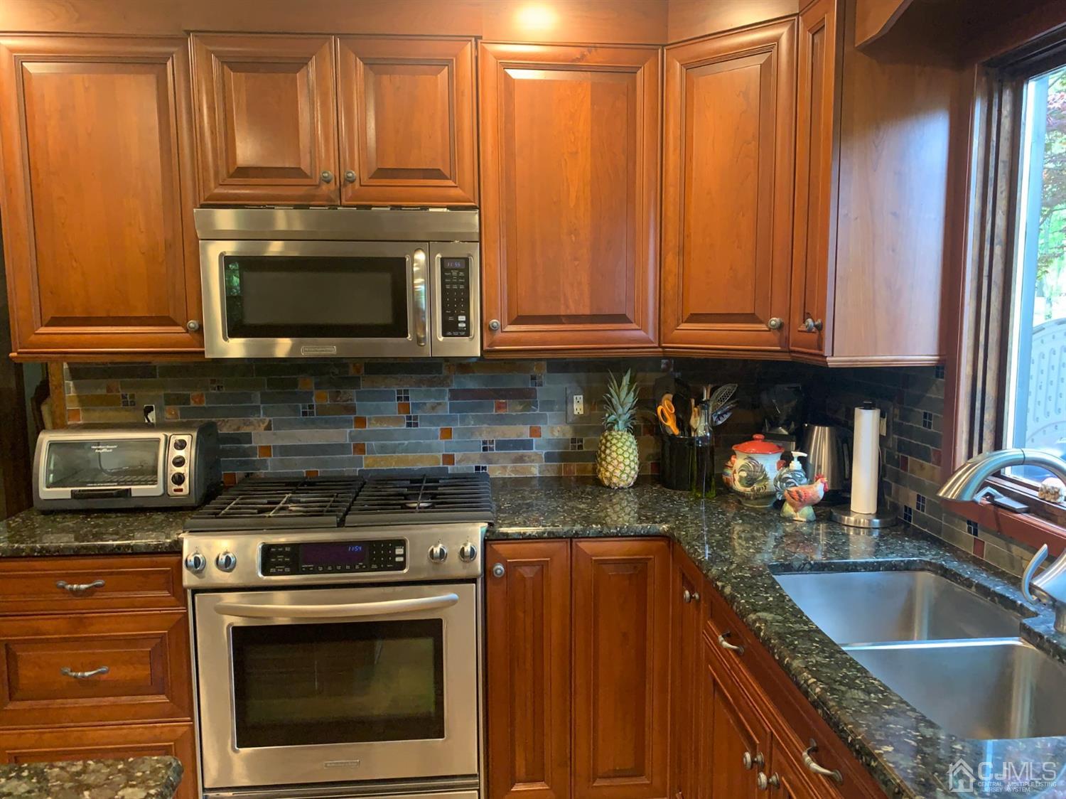 2 Fox Hill Road Edison, NJ 08820 - Photo 12 of 37 a kitchen with granite countertop a stove top oven microwave and cabinets