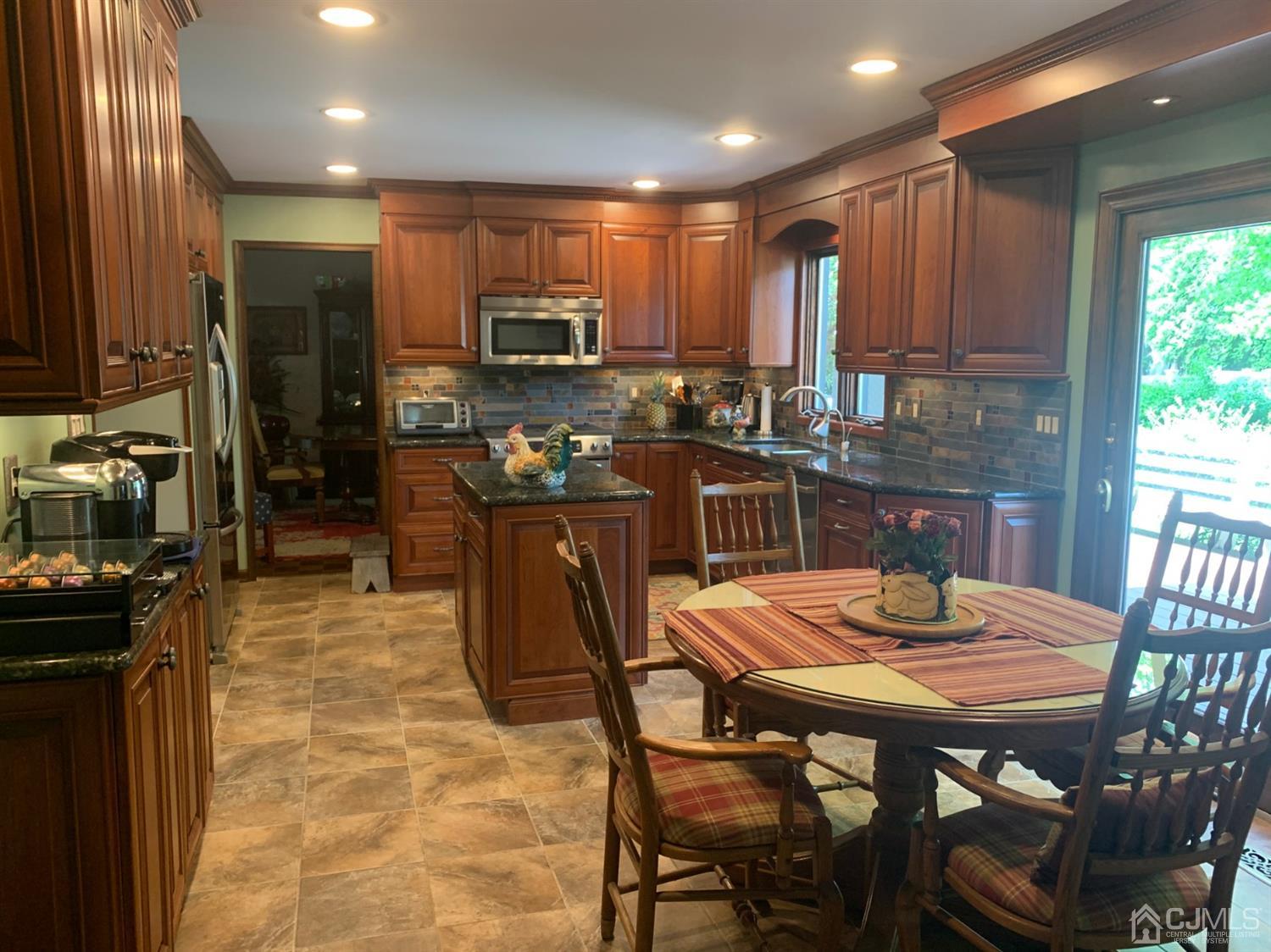 2 Fox Hill Road Edison, NJ 08820 - Photo 9 of 37 a kitchen with stainless steel appliances granite countertop a stove a refrigerator a kitchen island a table and chairs